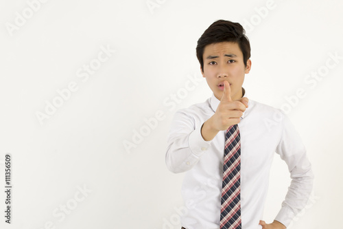 Serious young businessman pointing at you with index finger 