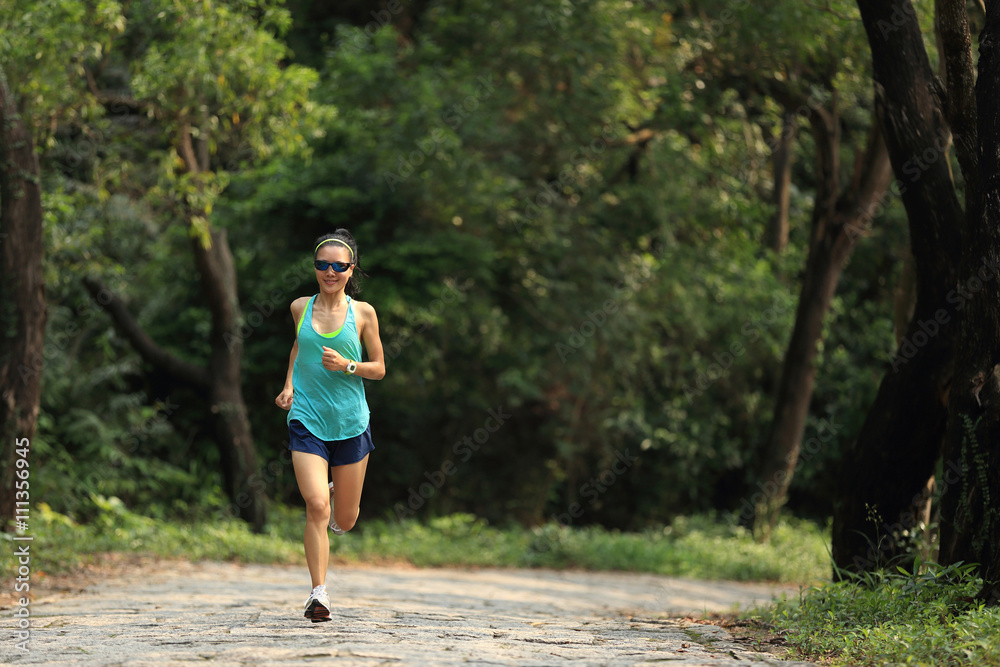 young fitness woman trail runner running in forest young fitness woman trail runner running in forest