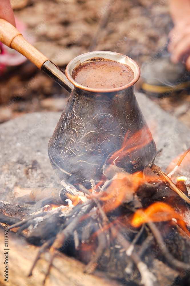Hot coffee prepared in turk on open fire. Closeup. Hot coffee prepared in turk on open fire. Closeup.