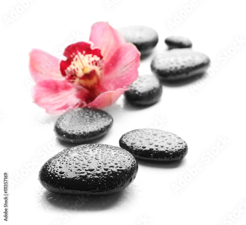 Spa stones and beautiful pink orchid on white background