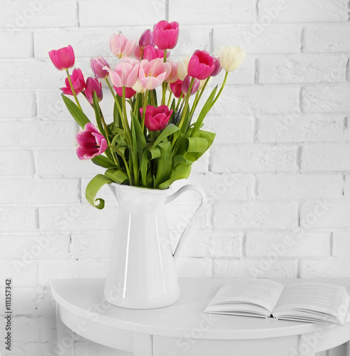 Fototapeta Naklejka Na Ścianę i Meble -  Beautiful tulips in vase on white brick wall background