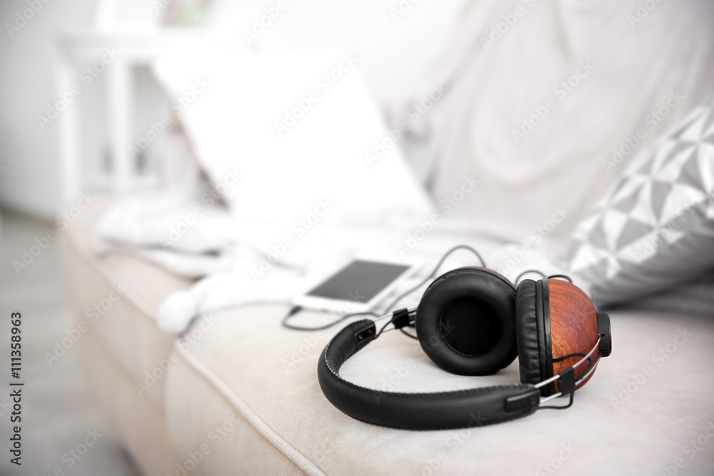 Stylish headphones and mobile phone on couch Stylish headphones and mobile phone on couch