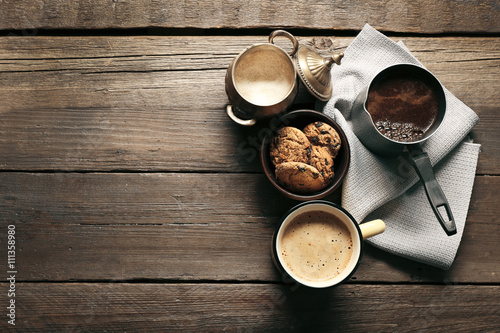 Mug of coffee with cookies on wooden table