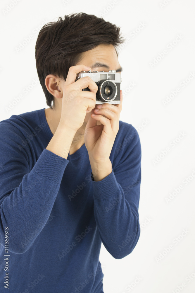 Asian young man taking photo by a old film camera Asian young man taking photo by a old film camera