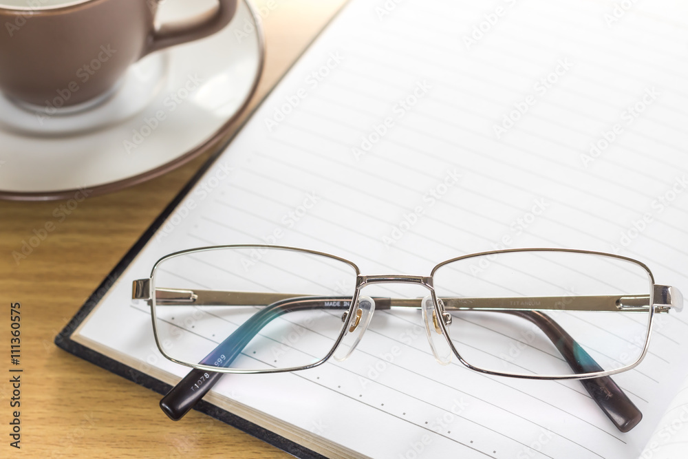 Eyeglasses put on note pad open blank page Eyeglasses put on note pad open blank page