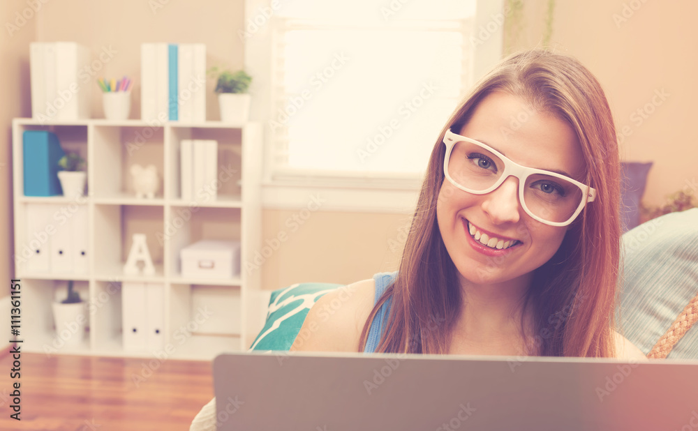 Young woman using her laptop on her couch Young woman using her laptop on her couch