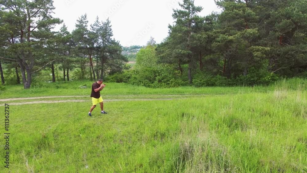 Aerial view of strong man doing exercise on the nature 4k Aerial view of strong man doing exercise on the nature 4k