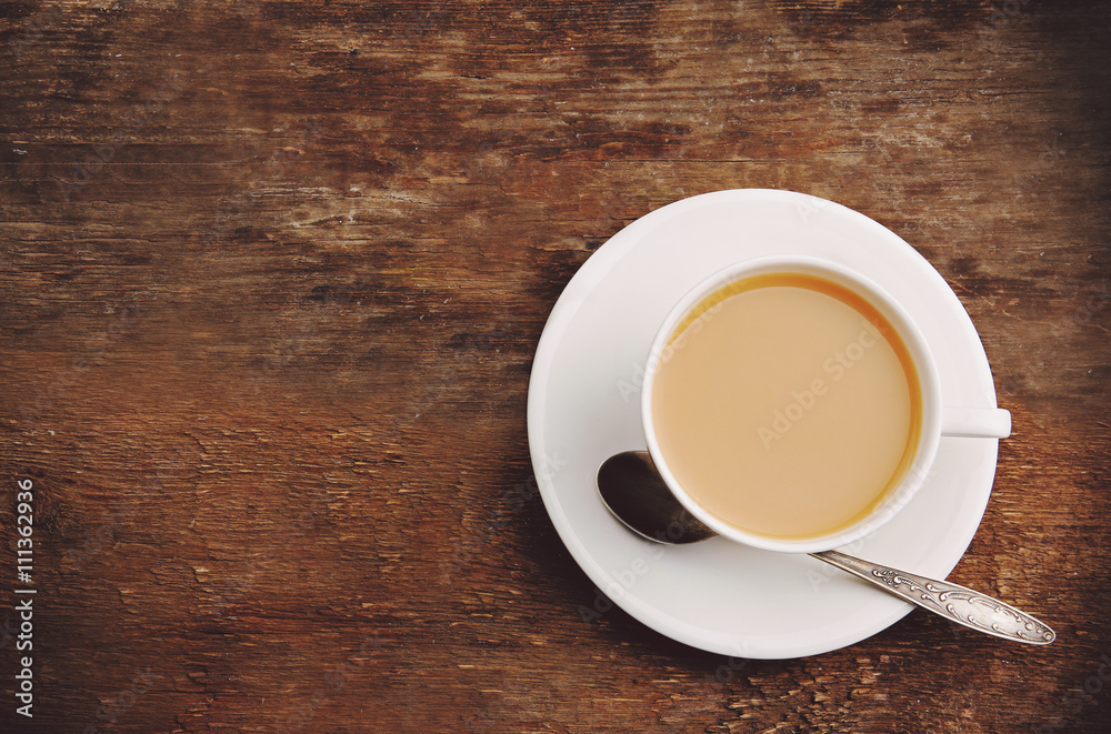 Porcelain cup of tea with milk on wooden background Porcelain cup of tea with milk on wooden background