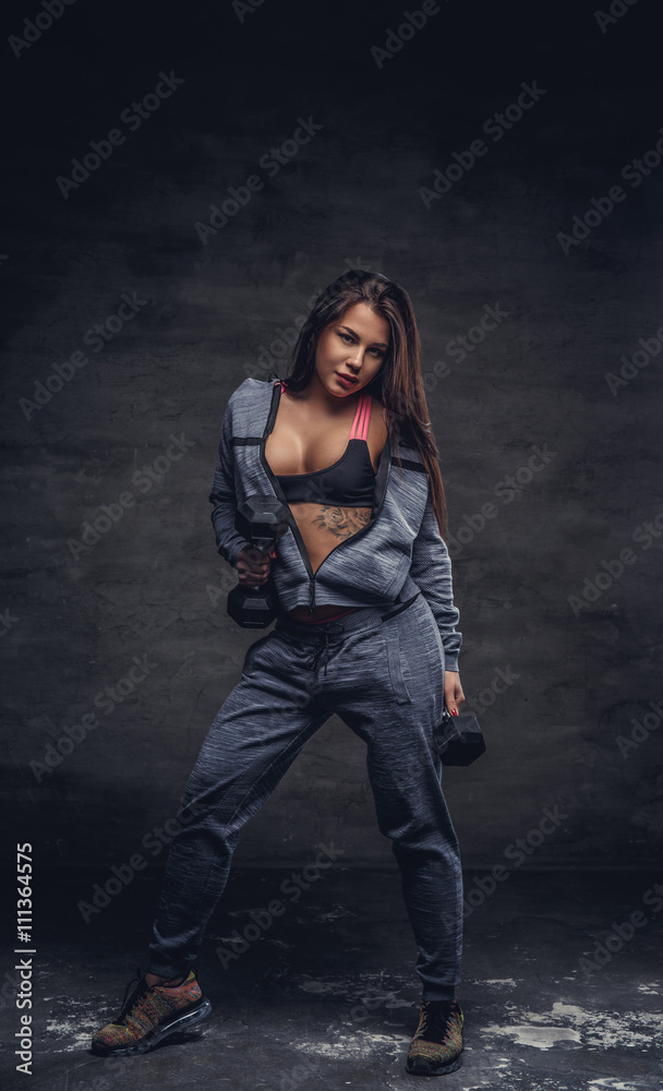 Sexy female undressing in studio over grey background.