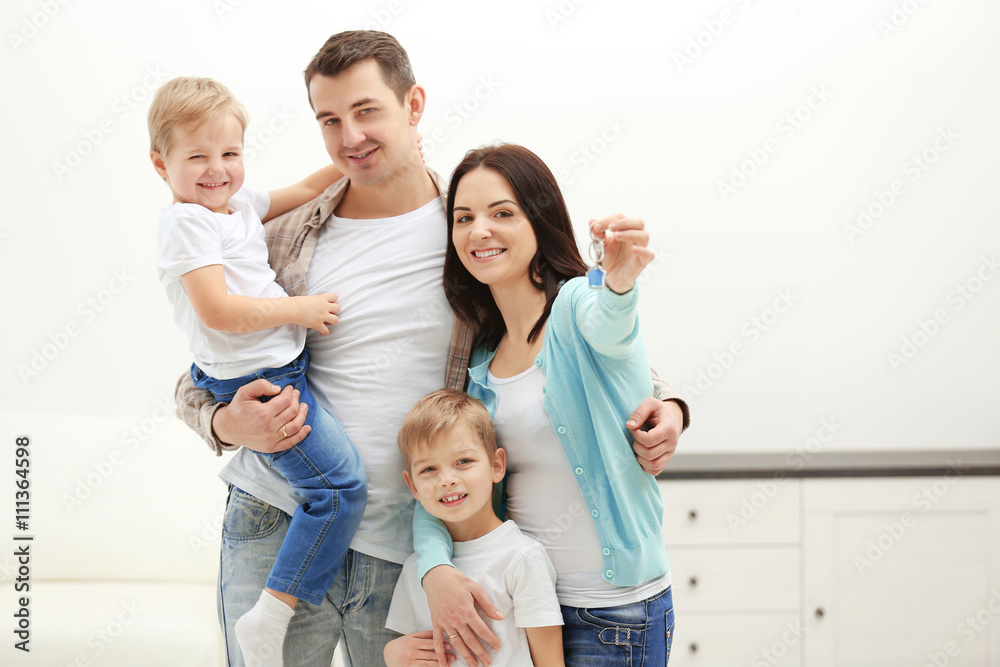 Happy family with key in new house, indoor Happy family with key in new house, indoor