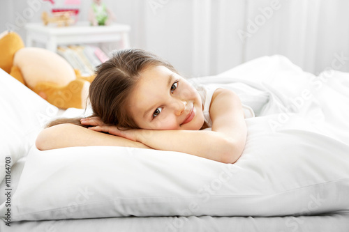 Little girl awake in bed
