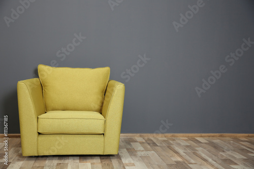Green armchair on dark grey wall background