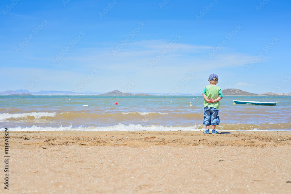 Small boy standing on the beach near Mar Menor