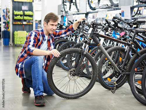 Man checks bike before buying in shop