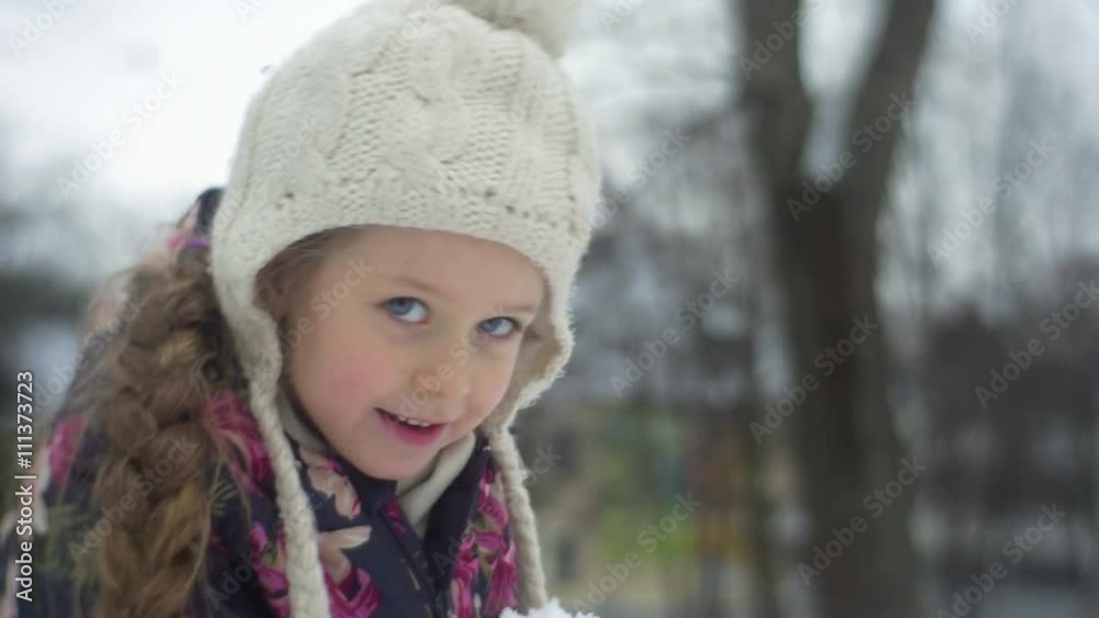 Kid Sits to a Ground Grabs the Heap of Snow Winter Little Girl is Raising up Smiling Buildings Snow Frosty Girl in Flowered Jacket and Pink Trousers Kid Sits to a Ground Grabs the Heap of Snow Winter Little Girl is Raising up Smiling Buildings Snow Frosty Girl in Flowered Jacket and Pink Trousers