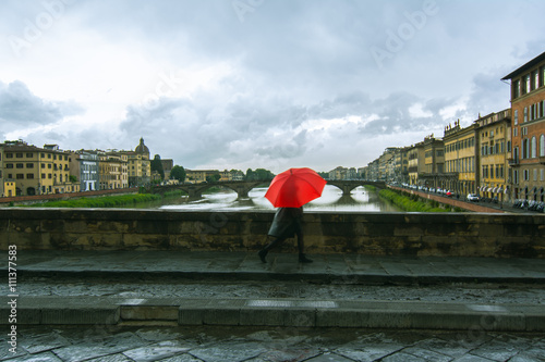 Maltempo a Firenze. Persona con ombrello rosso