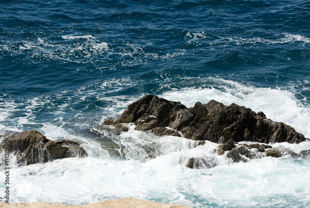 Wave splashing over a rock on Caleta Negra beach in Ajuy on Fuerteventura. Canary Island, Spain Wave splashing over a rock on Caleta Negra beach in Ajuy on Fuerteventura. Canary Island, Spain