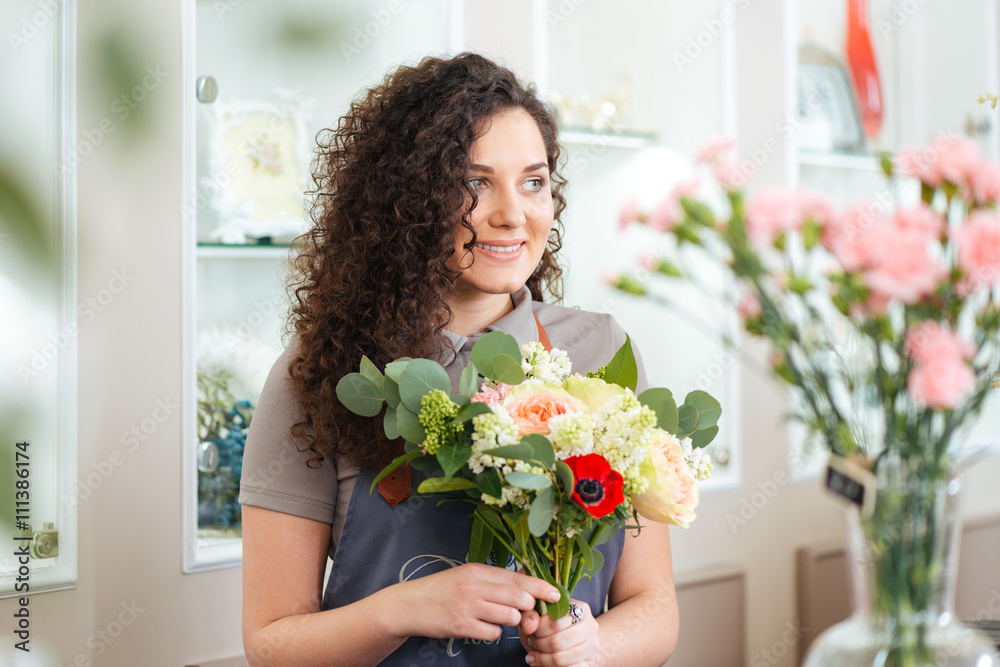 Happy woman florist working in flower shop