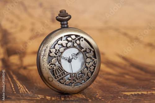 Pocket watch on old map background, vintage style light and tone