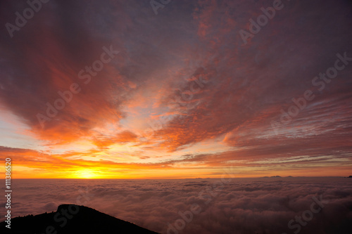 beautiful sunrise among foggy mountain summits landscape © lzf