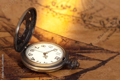 Pocket watch on old map background, vintage style light and tone