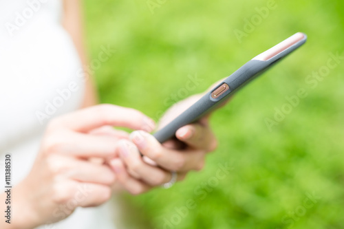 Woman using smart phone at green park
