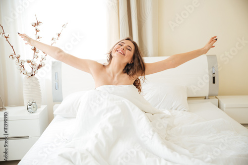 Woman stretching hands on the bed