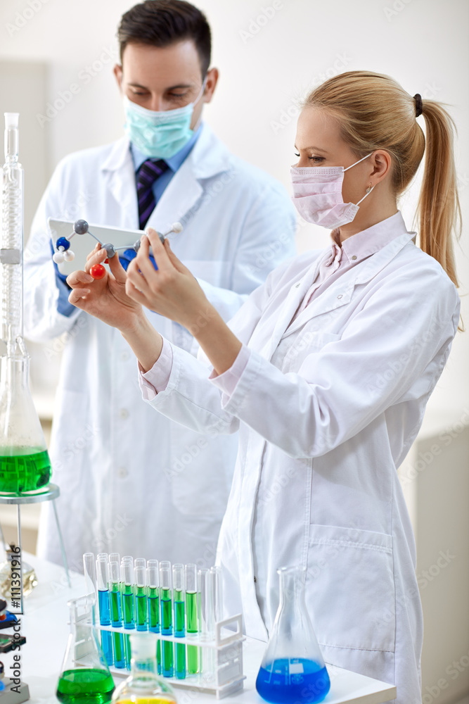Young female chemist holds molecular model.