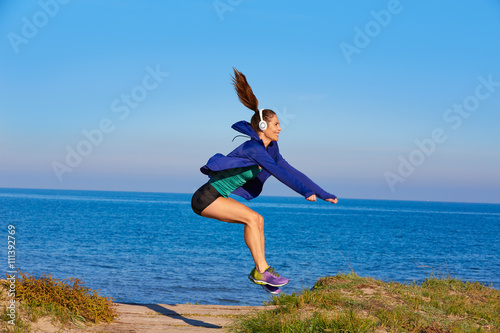Runner girl jumping exercise in beach dunes