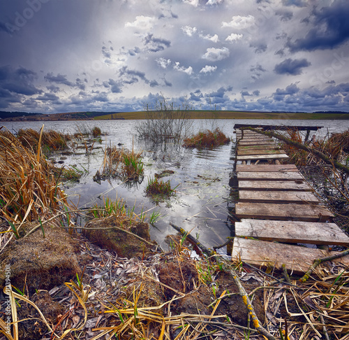 Old wooden pier with dry reed