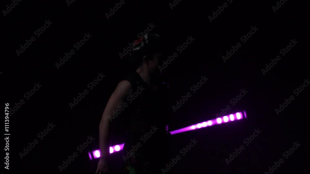 Juggler showing tricks with light balls in the whole dark.Close up.Slow motion