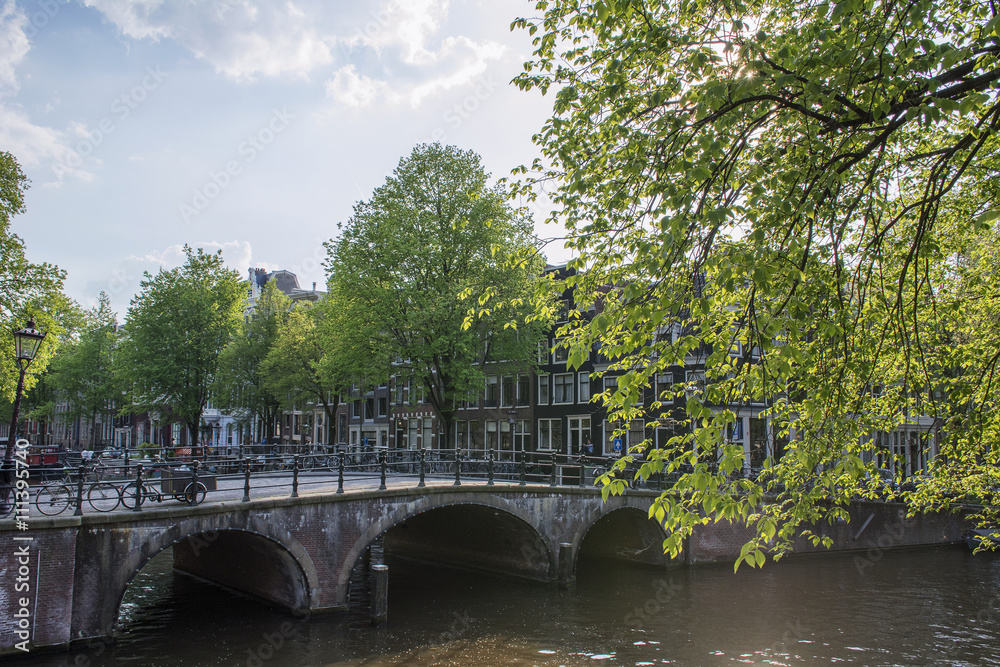 Old holland bridge and several houses in the sunny day in spring in Amsterdam
