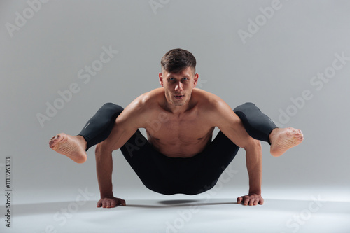 Handsome man doing yoga exercises