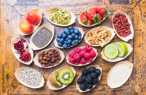 Healthy food berries, fruits, nuts, seeds top view on rustic wood background.Healthy, detox, super food concept.