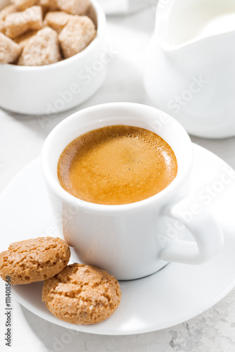 cup of espresso and almond cookies on a white table, closeup 