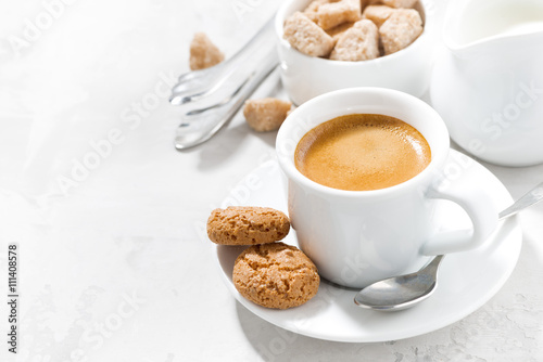 cup of espresso and almond cookies on a white table, horizontal