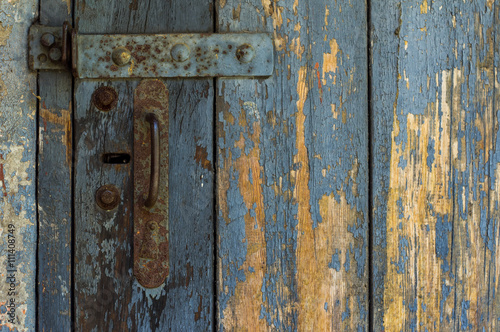 An Old Wooden Door With Cracked Paint. Background. Handle With Keyhole. The Old Iron. © mrzemer