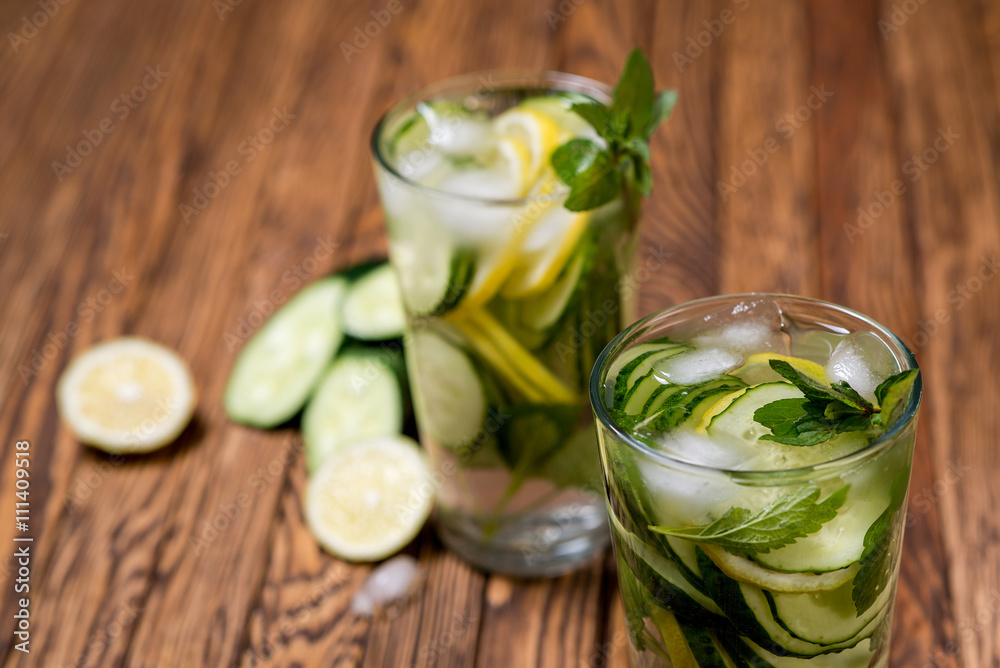 Water with lemon, mint and cucumber on wooden background. Water Detox.