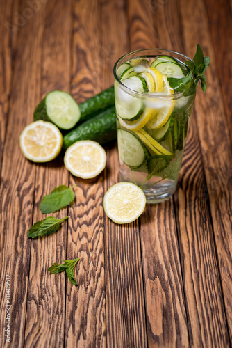 Water with lemon, mint and cucumber on wooden background. Water Detox.