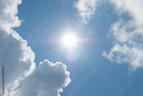 Sun and clouds against a blue sky. Day skyscape.