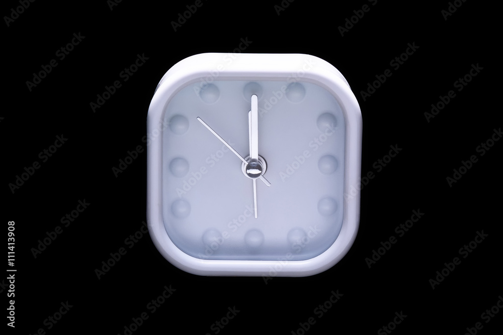 Twelve o'clock on white alarm clock on black background Twelve o'clock on white alarm clock on black background