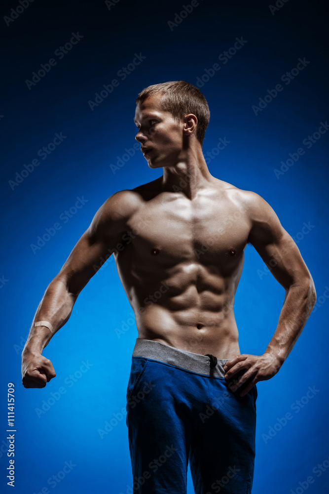 Fit young man with beautiful torso on blue background Fit young man with beautiful torso on blue background