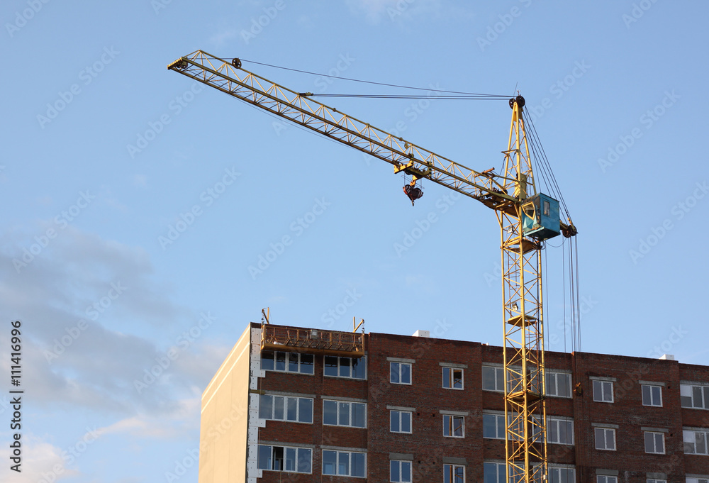 beautiful modern multistory building with construction crane in the final stages of construction