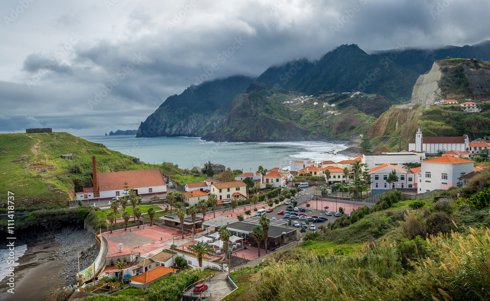 Madeira island, Porto da Cruz town and mountain peaks in the clouds landscape.