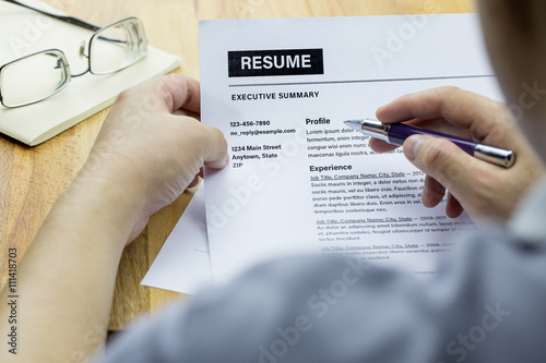 Foto Job seekers looking at his resume on wooden table and eye glasses