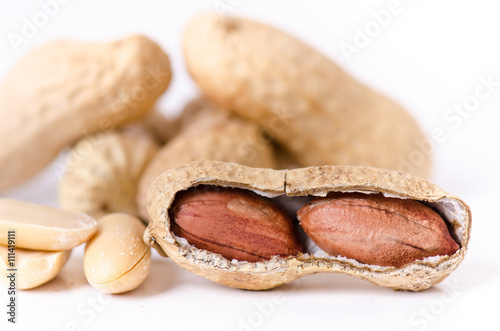 Peanuts on a white background. Isolated. Building from nuts. Balance. Open shell. Nutrition. Peanuts butter.