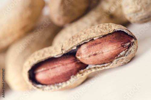 Peanuts on a white background. Isolated. Building from nuts. Balance. Open shell. Nutrition. Peanuts butter.