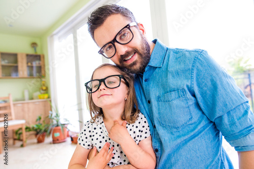 Father with his little daughter in black hipster eyeglasses photo