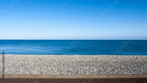 Εκτύπωση καμβά Seascape with pebble stone beach and sea defence wall on a beautiful day in Llan