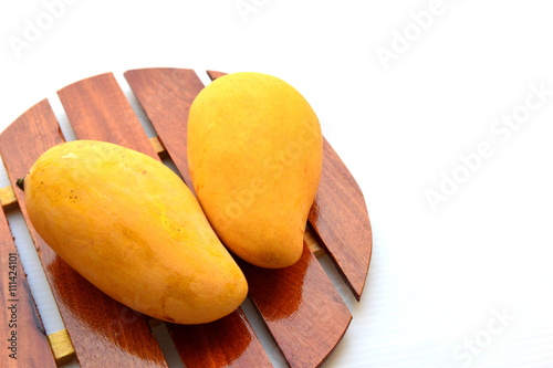Yellow mango on wooden tray